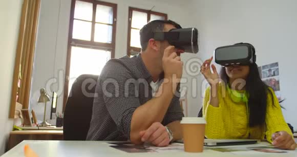 男性和女性平面设计师使用虚拟现实耳机在桌子4k视频的预览图