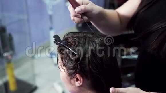 一个特写的慢镜头拍摄理发师准备客户头发角蛋白矫直这就是视频的预览图