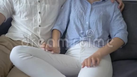 年轻女性满怀期待地告诉男人怀孕的事把手放在肚子上未来的父亲开心地坐着微笑视频的预览图