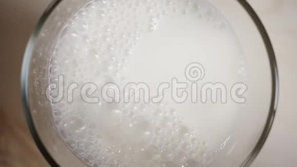 在浅棕色木桌上放满新鲜牛奶的顶景玻璃在米色上放满牛奶视频的预览图