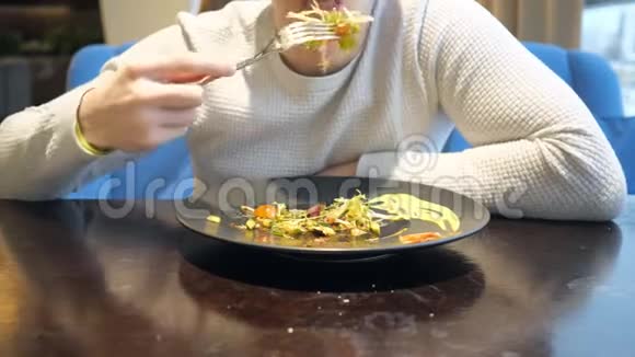 没脸的男人坐在咖啡馆里吃沙拉视频的预览图