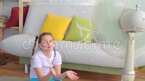 一个十几岁的女孩在一个受炎热天气影响的粉丝旁边的肖像视频的预览图