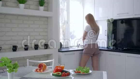 健康的怀孕关心未来的母亲在健康的早餐中喝新鲜的维生素汁和抚摸腹部视频的预览图