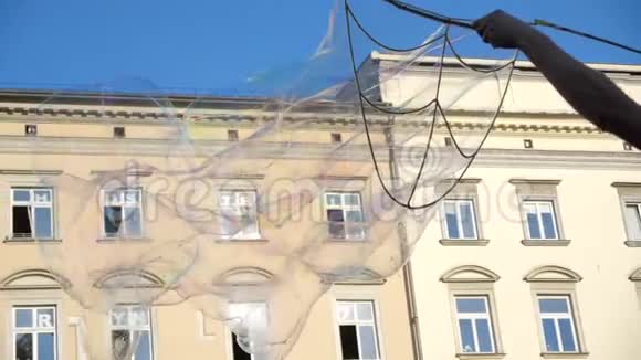 夏天一个女孩在克拉科夫广场上制造了几十个五颜六色的肥皂泡视频的预览图