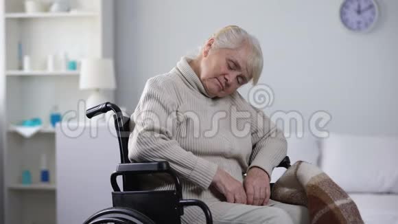 年轻的护士为躺在轮椅上的老妇人做掩护照顾她视频的预览图