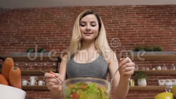 年轻的健康女性正在准备一份纯素沙拉新鲜的绿色蔬菜在锻炼后使用橄榄油健康和健康视频的预览图