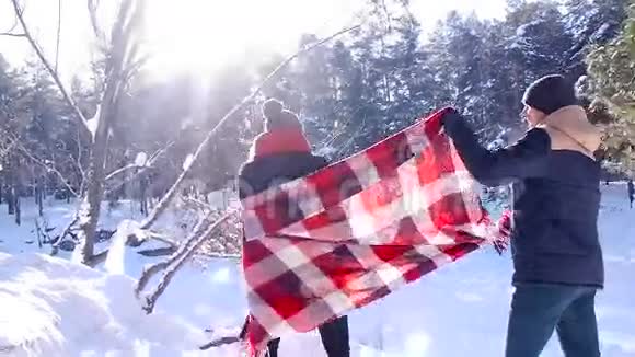 年轻漂亮的情侣在冬天的树林里散步视频的预览图