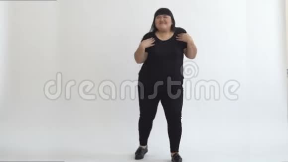 正宗的亚洲胖女孩在白色背景下跳舞和享受生活今天青年的陈规定型观念之外生活视频的预览图