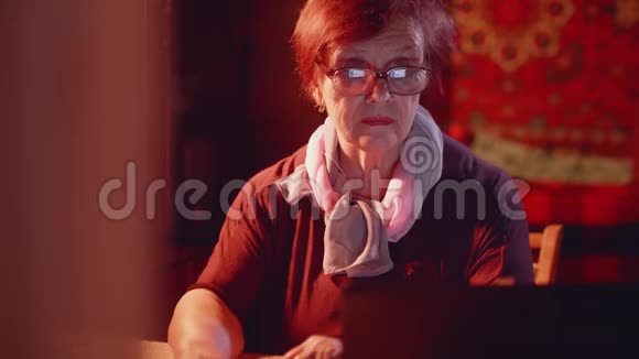 漂亮的高级女性在她的笔记本电脑上上网斯克伦反映在眼镜上视频的预览图