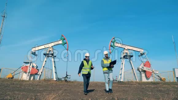 男性能量学工作者正在远离油泵井架石油工业石油工业石油部门视频的预览图