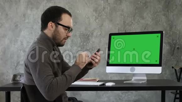他在电脑屏幕附近的办公室里检查牙齿绿屏模拟显示视频的预览图