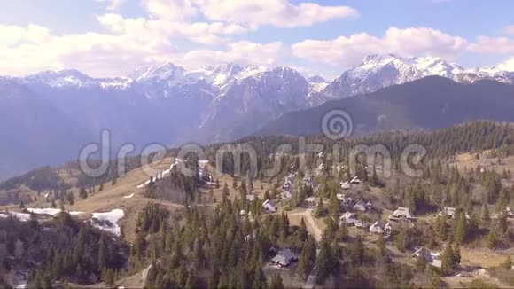 从后面飞起美丽的维利卡平原里面满是云杉小房子和山空中飞行视频的预览图