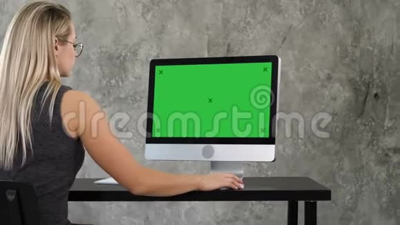 年轻的商务女性在办公室内部工作在电脑上办公桌打字看屏幕绿屏模拟显示视频的预览图