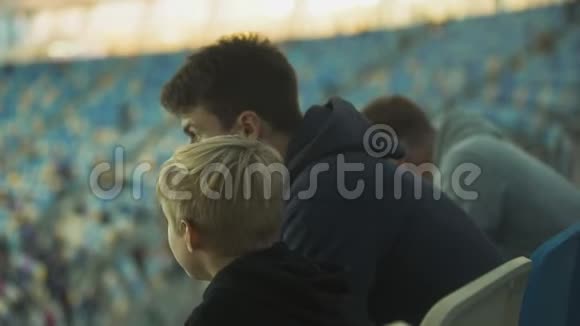 哥哥在体育场向男孩解释体育游戏规则兄弟情谊视频的预览图
