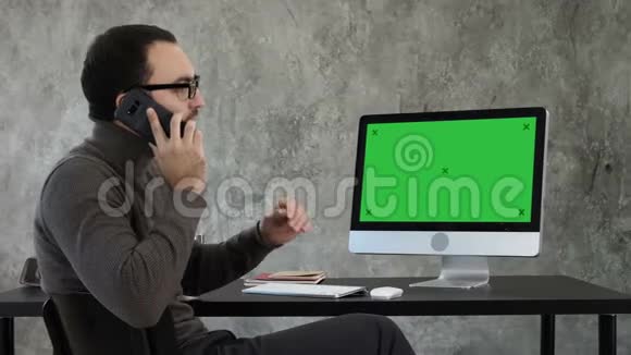 建筑师在电脑屏幕上打电话讨论项目绿屏模拟显示视频的预览图