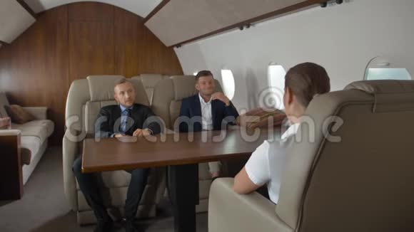 两位自信的男企业家和成功的女商人坐飞机视频的预览图