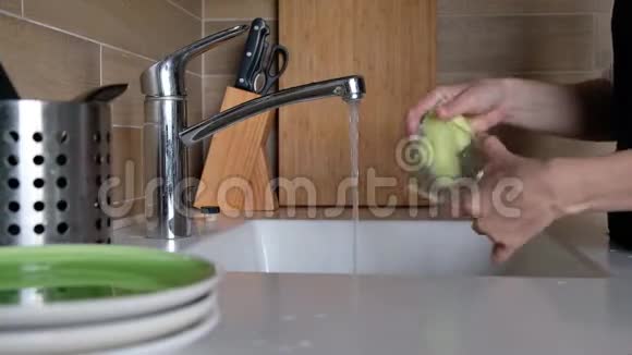 女人的手在厨房水槽里冲洗眼镜在家里做家务洗碗常规静态摄像头快关门视频的预览图
