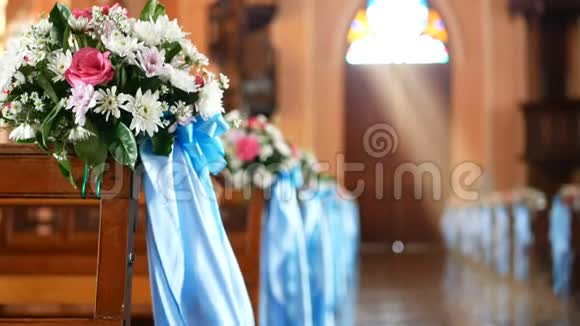 4K空教堂的内部景观木制长凳上装饰着花束和被风吹过的蓝色丝带视频的预览图