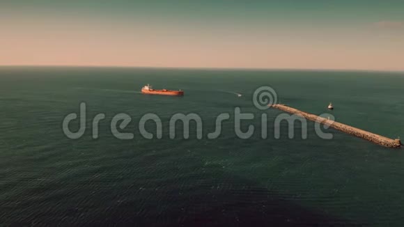 未知红色油轮在海港附近海上航行的鸟瞰图视频的预览图