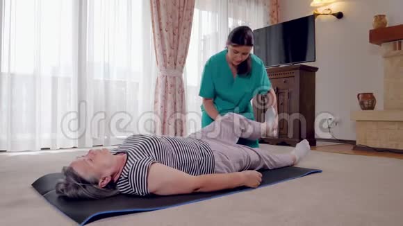 年轻治疗师与年长女性病人在疗养院锻炼视频的预览图