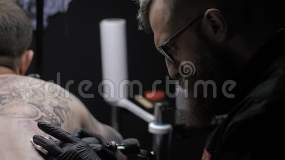 专业纹身师展示背面纹身的过程视频的预览图