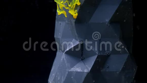 一个抽象的人物站在水下气泡上升黄色的油漆墨水从上面倒在黑色上视频的预览图
