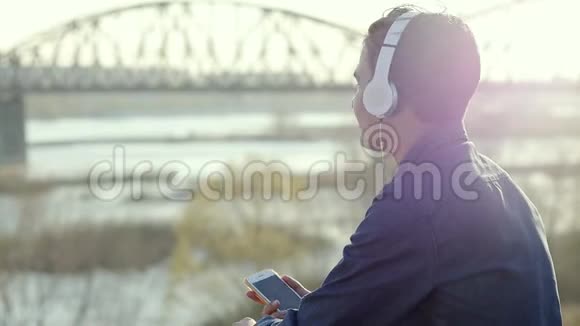 亚裔混血黑发少年带着耳机听音乐视频的预览图