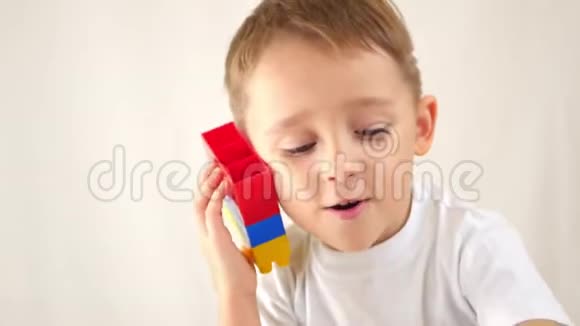 孩子玩彩块模拟白色背景上的电话对话儿童的概念视频的预览图