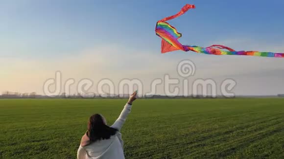 日落时分美女带着风筝在绿野上奔跑视频的预览图