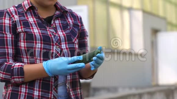 一位戴着蓝色手套的女园丁正在温室里抱着新鲜的黄瓜视频的预览图