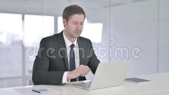 在笔记本电脑上进行视频聊天的中年商务人士视频的预览图