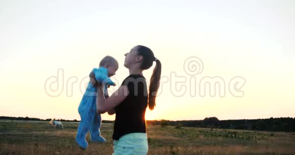 斯洛莫日落时分一位情绪激动的年轻女子在田野里手抱婴儿视频的预览图