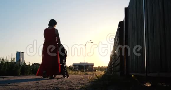 浪漫的女人穿着红色的裙子在日落时分骑着婴儿车在斯洛文尼亚视频的预览图