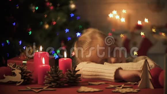 妈妈抚摸着漂亮的女孩在美丽的圣诞装饰附近睡着了家视频的预览图