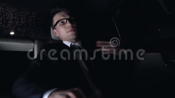 紧张的商人坐在汽车后座上担心工作晚上视频的预览图