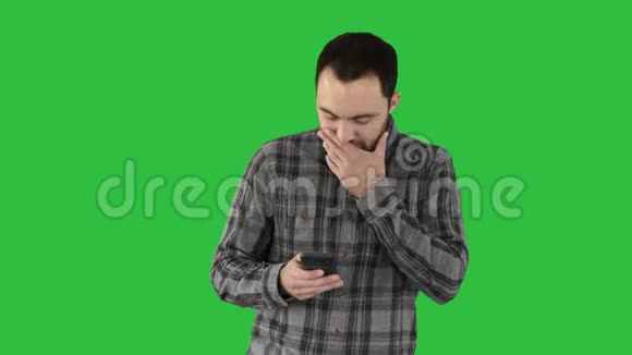 悲伤的年轻人走着看着他的手机他的手在他的脸上的绿色屏幕Chroma键视频的预览图