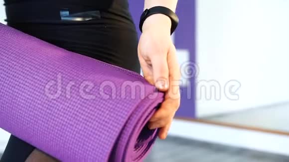 女子手中的紫色瑜伽垫特写视频的预览图