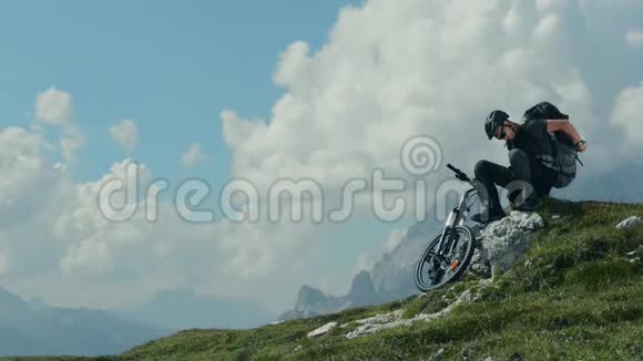 山地自行车运动员休息和欣赏大山景视频的预览图