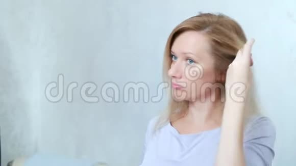 脱发秃顶一个金发女人把头发拉直手里还留着一簇头发复制空间视频的预览图