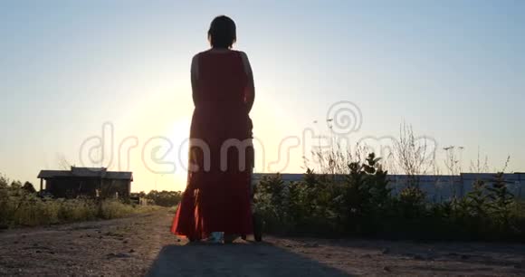 可爱的女人穿着红色的裙子在日落时分骑着婴儿车骑在斯洛文尼亚视频的预览图