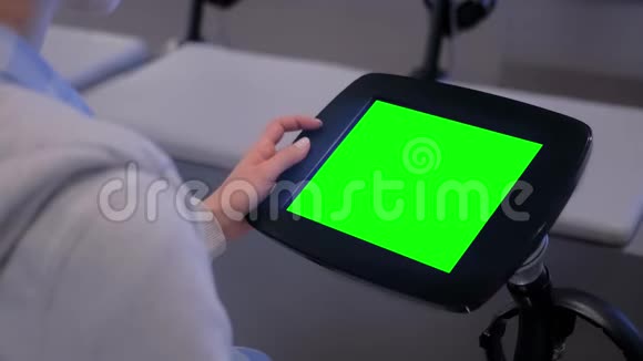 绿色屏幕概念女人看展示地面站立的平板电脑亭视频的预览图