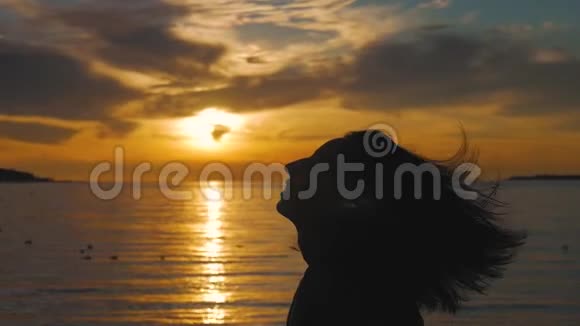 在温暖的夕阳下一个女人的侧影呼吸着深深的新鲜空气视频的预览图