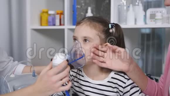 一位女儿科医生和一个小女孩的肖像她戴着医院雾化器吸入面罩视频的预览图