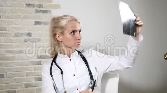 在医疗诊所年轻可爱的女医生拿着x光在医院检查放射科医生4k视频的预览图
