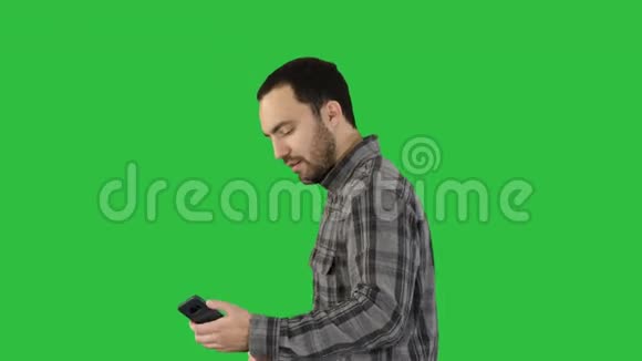 青少年男孩在绿色屏幕上行走时自拍Chroma键视频的预览图