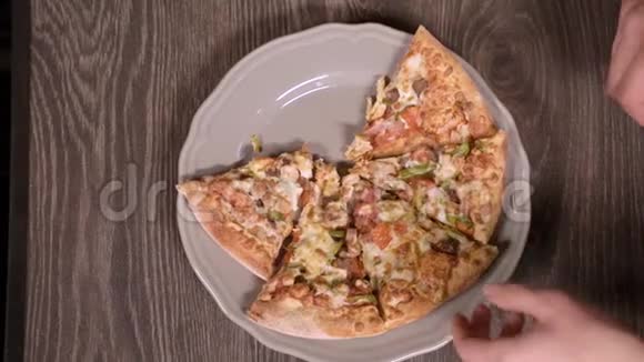切片比萨饼放在一个圆形的灰色盘子里手拿着所有的披萨视频的预览图