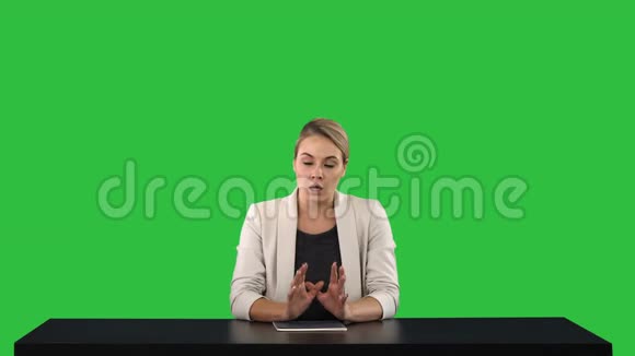 一个女新闻播报员呈现新闻在她身后的绿色屏幕上添加你自己的文本或图像屏幕Chroma键视频的预览图