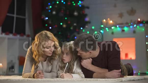 家庭写圣诞愿望清单躺在装饰精美的房间里灯光闪烁视频的预览图