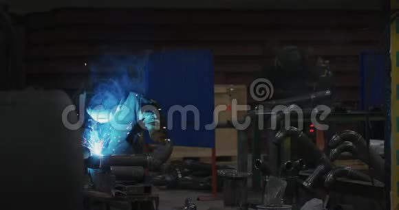 焊工在焊接面罩在工厂工作服焊接管道在工厂房间视频的预览图