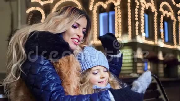 母亲和小女孩在装饰中享受圣诞假期照亮了背景视频的预览图